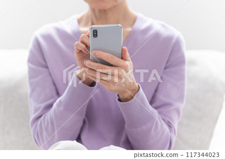Senior woman operating a smartphone 117344023