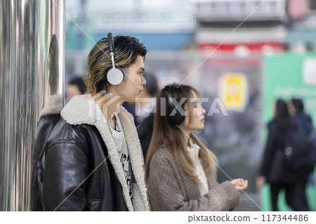 Young man wearing headphones, profile 117344486