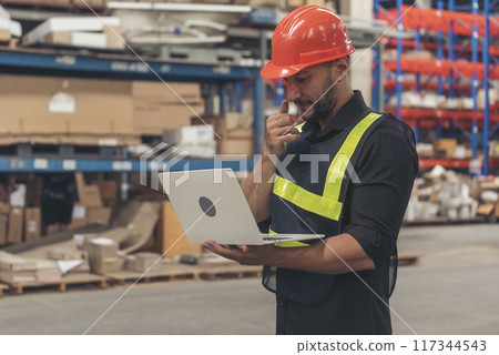 Hispanic men hands using typing laptop computer Warehouse management logistics counting checking products on inventory shelf. Engineer Man hands checklist stock control computer program in storage 117344543