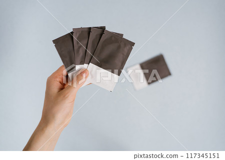 Disposable bags with cosmetics in a woman's hand on a blue background 117345151