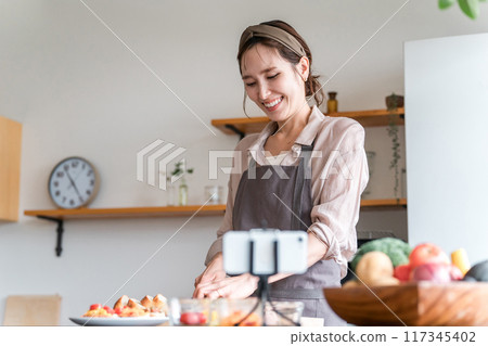 A female cooking class instructor delivering an online cooking class via smartphone A female cooking class instructor delivering an online cooking class via smartphone 117345402