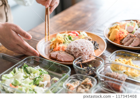A housewife serving a one-plate lunch in the kitchen 117345408