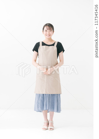 Female cafe staff wearing an apron Female cafe staff wearing an apron 117345416