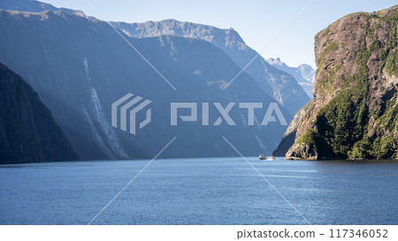 Tourist sightseeing boats sailing through fjord with steep rocky walls, Fiordland, New Zealand Tourist sightseeing boats sailing through fjord with steep rocky walls, Fiordland, New Zealand 117346052