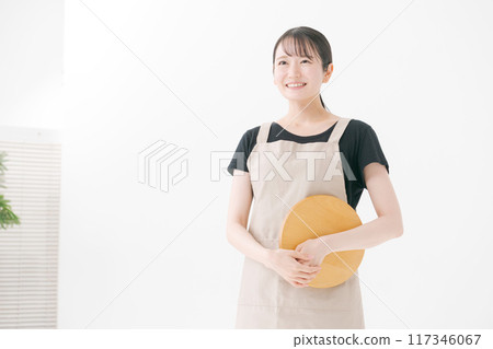 Female cafe staff wearing an apron Female cafe staff wearing an apron 117346067