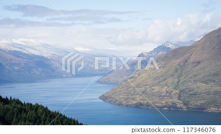 Beautiful alpine landscape with snowy mountains, blue lake and dense coniferous forest, New Zealand Beautiful alpine landscape with snowy mountains, blue lake and dense coniferous forest, New Zealand 117346076