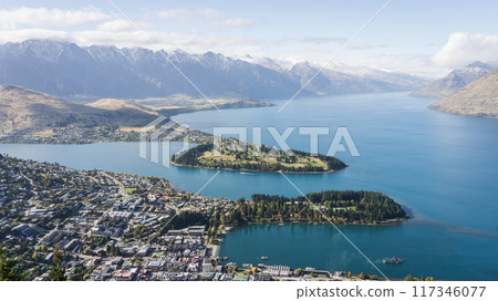 View on busy mountain town located on a lake shore surrounded by beautiful mountains, New Zealand 117346077
