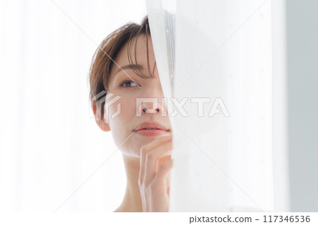 中年婦女透過窗簾偷看 中年婦女透過窗簾偷看 117346536
