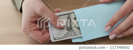 Female hands getting pack of dollars from envelope Female hands getting pack of dollars from envelope 117346692