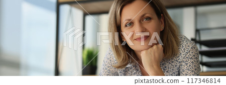 Smiling woman architect standing near desk with rolls of blueprints Smiling woman architect standing near desk with rolls of blueprints 117346814