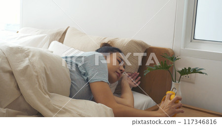 Asian women sleep wake up in white cozy bedroom happy time morning sunrise. Beautiful chinese use hand stop time alarm clock. Happy person lifestyle wake up in morning wellbeing relax sleepy napping Asian women sleep wake up in white cozy bedroom happy time morning sunrise. Beautiful chinese use hand stop time alarm clock. Happy person lifestyle wake up in morning wellbeing relax sleepy napping 117346816
