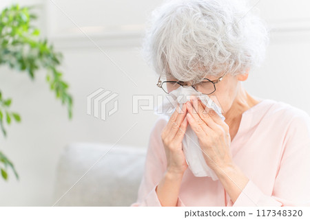 Senior woman biting his nose with tissue Senior woman biting his nose with tissue 117348320