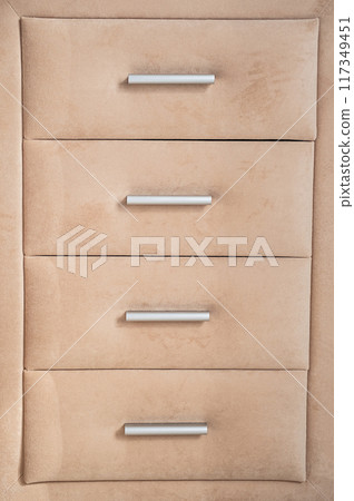 Beige cushioned dresser featuring drawers with sleek silver handles. Beige cushioned dresser featuring drawers with sleek silver handles. 117349451