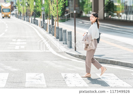 Business woman/working mother crossing the crosswalk Business woman/working mother crossing the crosswalk 117349926
