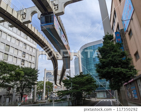 A suspended monorail that travels between the buildings of a city 117350292