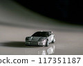 A vibrant toy car proudly perched atop a table, ready for its next adventure. 117351187