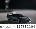 In the shadows, a toy car waits patiently, a symbol of childhood dreams and possibilities. 117351194