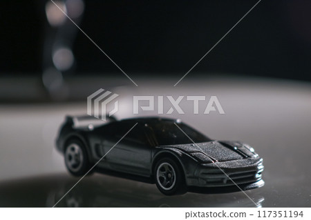 In the shadows, a toy car waits patiently, a symbol of childhood dreams and possibilities. 117351194