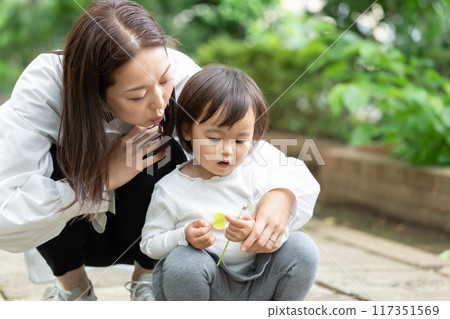 Parent and child playing in the park 117351569