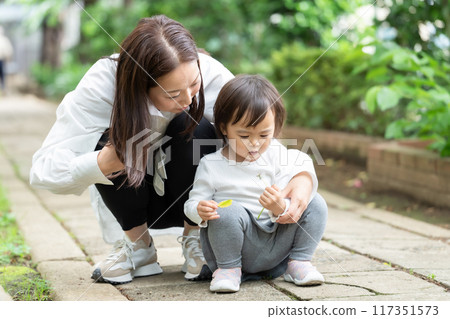 Parent and child playing in the park 117351573
