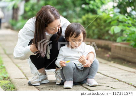 Parent and child playing in the park 117351574