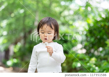 一個女孩跳過蒲公英的絨毛 117351586
