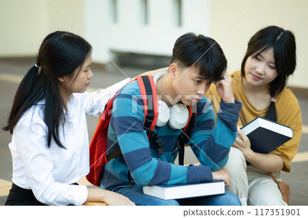 Friends comforting stressed student on campus 117351901