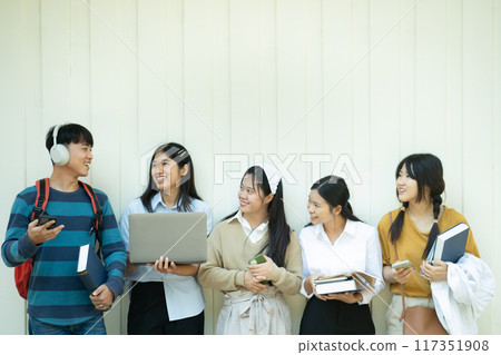 Students using technology and books for study 117351908