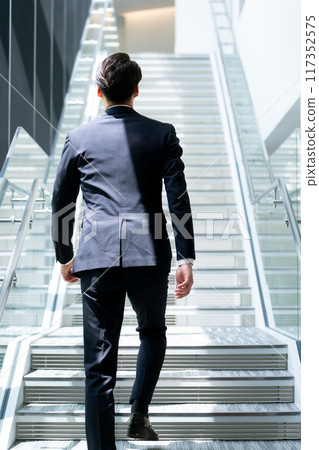 K businessman climbing the stairs 117352575