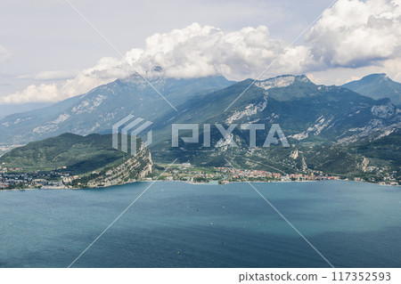 Tranquil waters of Lake Garda complement the picturesque town of Torbole with Monte Baldo looming 117352593