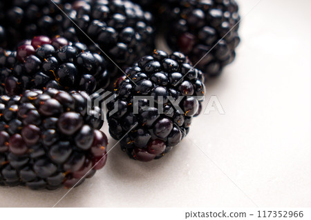 Fresh ripe juicy blueberry on a white ceramic surface. Sweet healthy organic vitamin berries. Macro shot 117352966