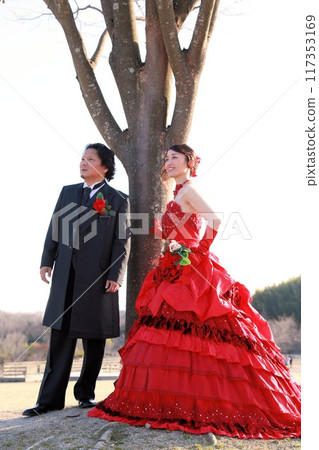 Photo wedding of a bride in a red colored dress and a groom in a tuxedo 117353169