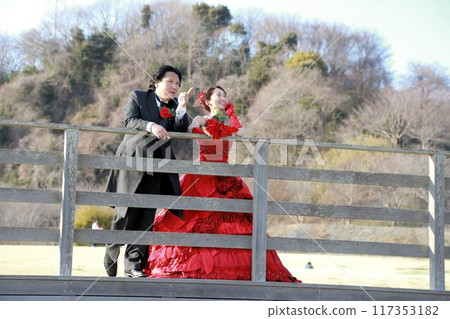 Photo wedding of a bride in a red colored dress and a groom in a tuxedo Photo wedding of a bride in a red colored dress and a groom in a tuxedo 117353182