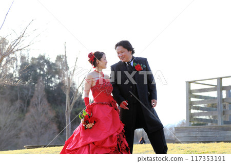 Photo wedding of a bride in a red colored dress and a groom in a tuxedo 117353191