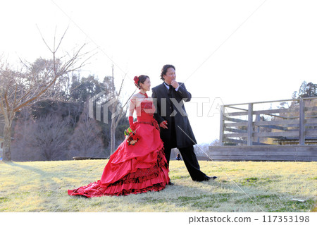 Photo wedding of a bride in a red colored dress and a groom in a tuxedo Photo wedding of a bride in a red colored dress and a groom in a tuxedo 117353198