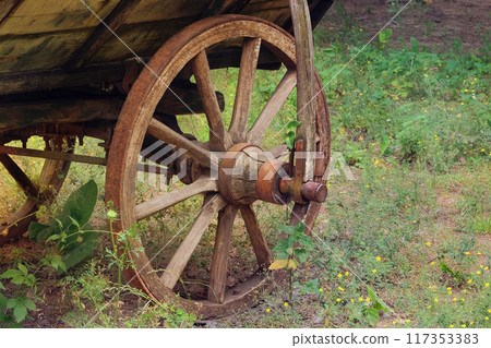 Wooden wheel. Old wooden cart. Rural transport in nature landscape. Wooden wheel. Old wooden cart. Rural transport in nature landscape. 117353383