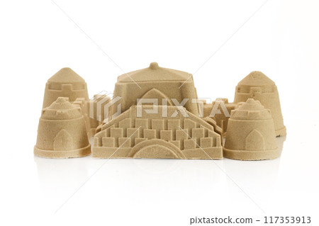 A detailed sandcastle made from fine sand, isolated on a white background 117353913