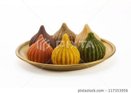 Ganesh Chaturthi Festival. Colorful Modaks Indian sweet dumpling on Plate Ganesh Chaturthi Festival. Colorful Modaks Indian sweet dumpling on Plate 117353956