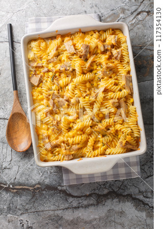 Tuna casserole pasta bake with a creamy sauce, sweet corn and crunchy topping, baked until golden closeup on the baking dish. Vertical top view Tuna casserole pasta bake with a creamy sauce, sweet corn and crunchy topping, baked until golden closeup on the baking dish. Vertical top view 117354130