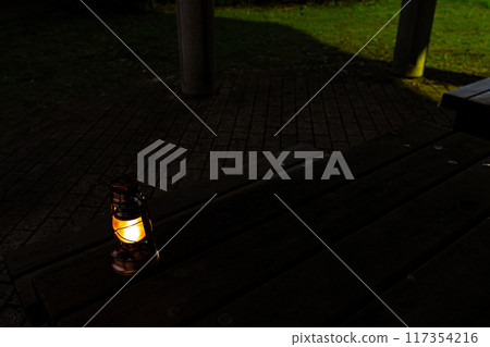 Antique lantern on a table in the park Antique lantern on a table in the park 117354216