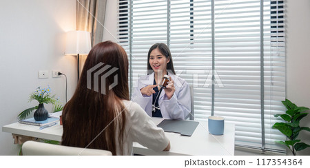 Female Doctor Consulting Patient in Modern Medical Office with Natural Light and Greenery 117354364