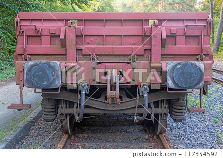 Picture of an cargo railroad car standing on a track photographed from the ground perspective 117354592