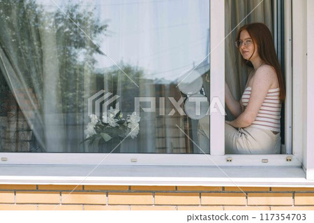 blend of technology and daily chores as a window cleaning robot polishes glass, while the girl is drinking tea blend of technology and daily chores as a window cleaning robot polishes glass, while the girl is drinking tea 117354703