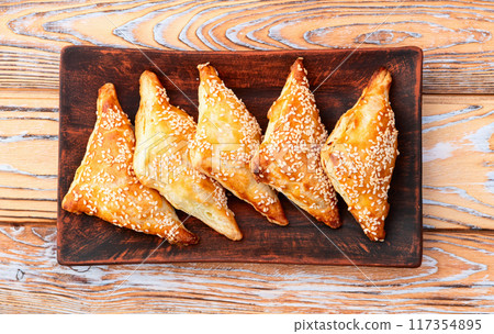 Homemade triangle puff pastry with meat on rustic background . Samosa Homemade triangle puff pastry with meat on rustic background . Samosa 117354895