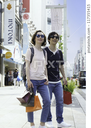 Inbound foreign tourist couple shopping in Ginza vertical position Inbound foreign tourist couple shopping in Ginza vertical position 117355415