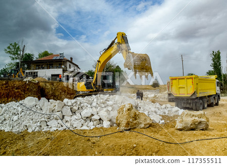 Excavator work at construction site. Excavator digs a hole. 117355511