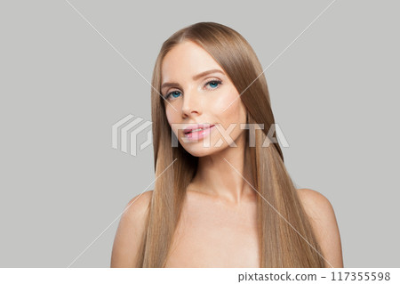 Cheerful woman with long healthy straight shiny hairstyle, make-up and fresh skin posing  117355598