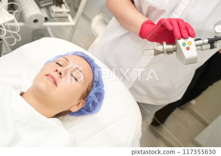 Face procedure. Professional dermatologist uses modern technology Face procedure. Professional dermatologist uses modern technology 117355630