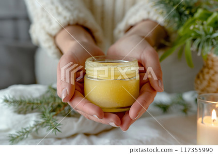 Close-up of hands holding a homemade herbal hand salve for moisturizing skin care Close-up of hands holding a homemade herbal hand salve for moisturizing skin care 117355990