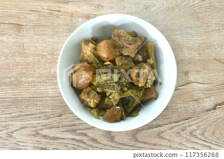 boiled mixed vegetable with braised pork bone in black soybean soup in bowl on table boiled mixed vegetable with braised pork bone in black soybean soup in bowl on table 117356268